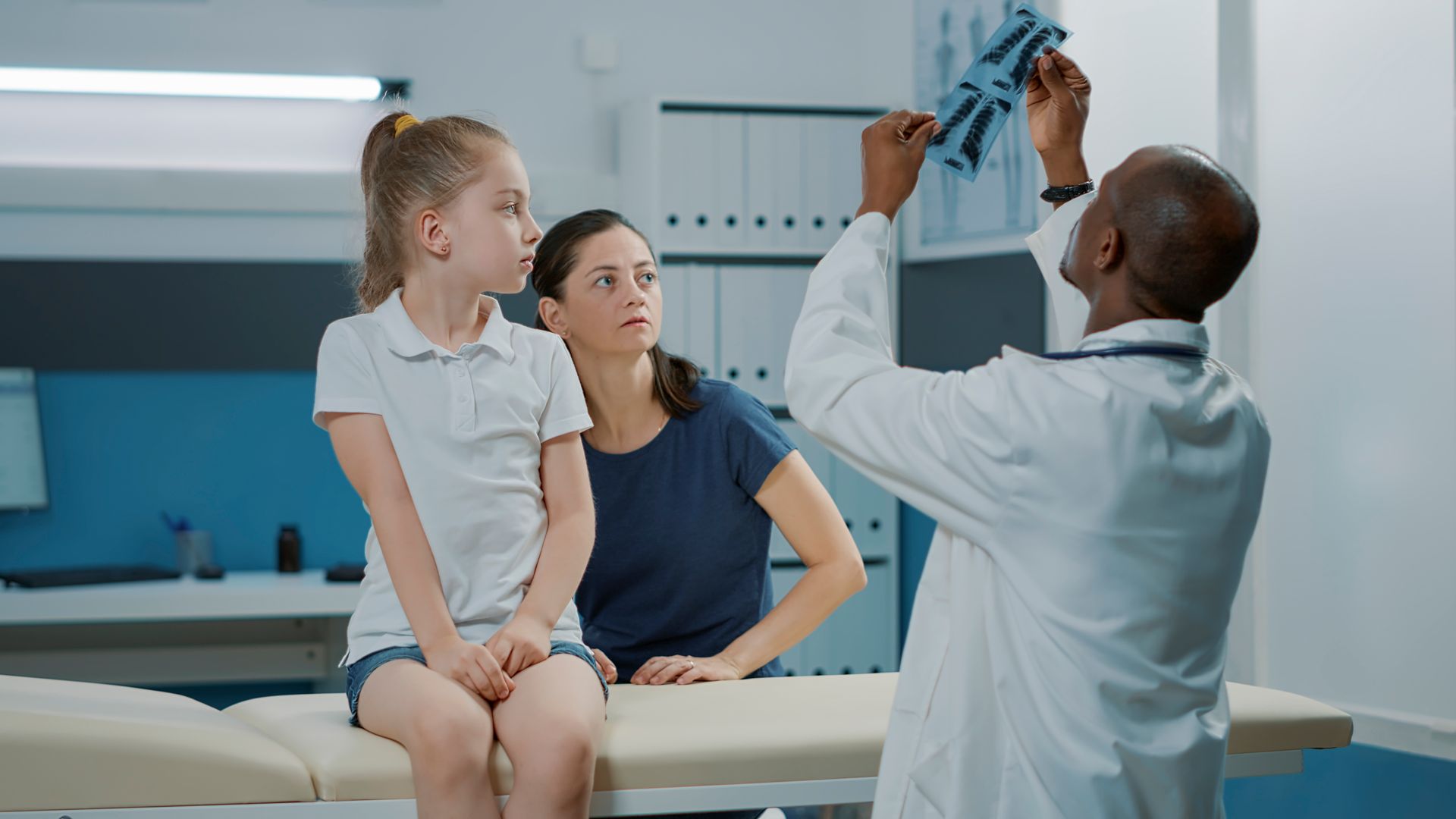 Homme spécialiste en train de vérifier la radiographie d'un enfant