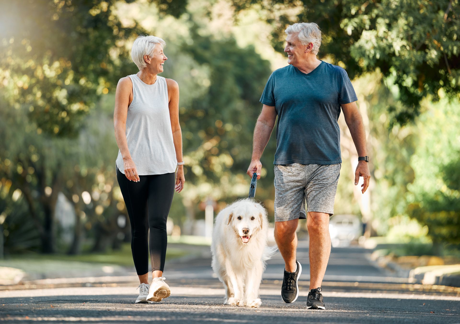 Femme et homme d'un certain âge, promenant leur chien