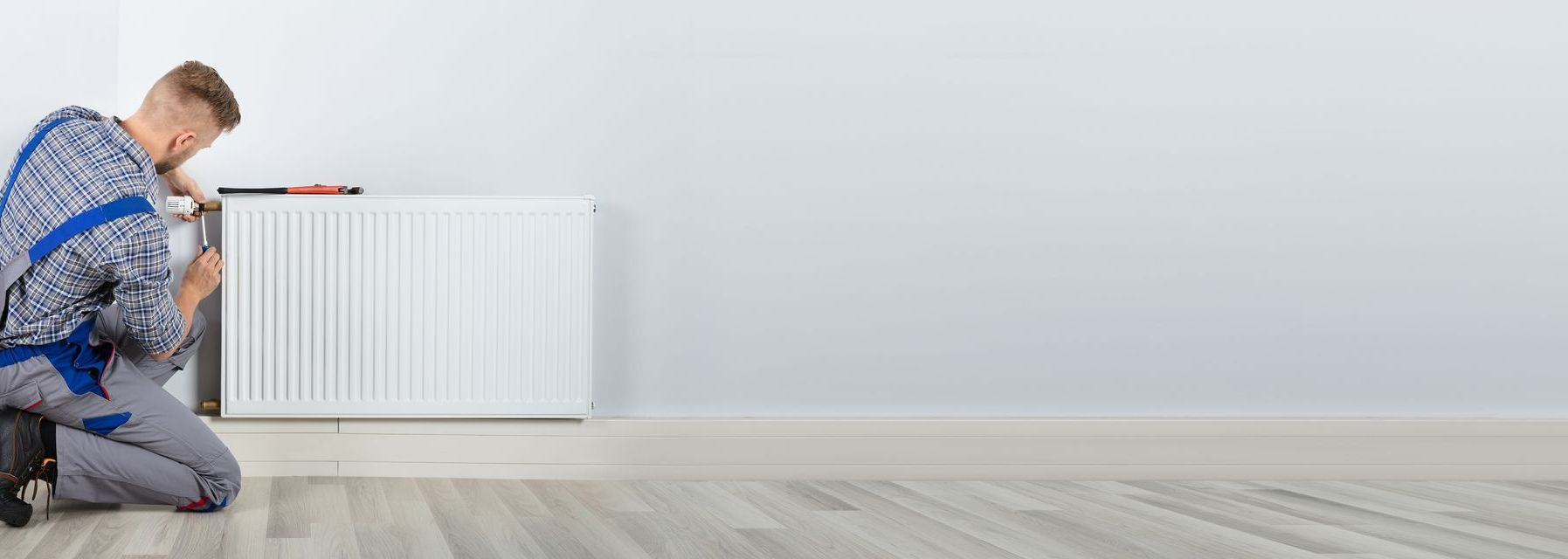 Un artisan installe un radiateur