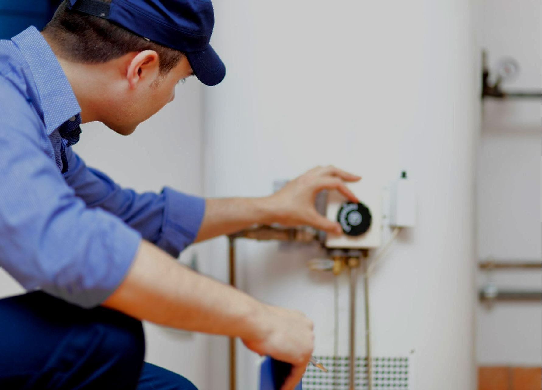 Un chauffagiste règle une chaudière