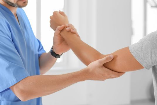 Physiotherapeut behandelt einen Arm