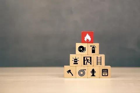 Una pirámide de bloques de madera con iconos relacionados con el fuego en ellos.
