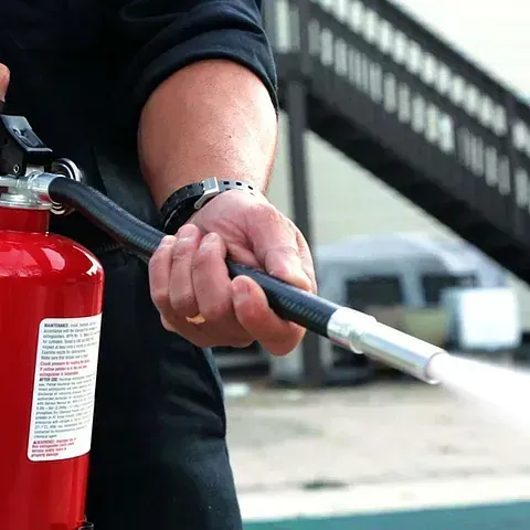 Una persona sostiene un extintor en su mano.