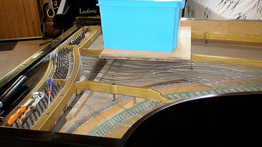 Près de Mulhouse : facteur de pianos Ludovic Ribouleau - Démontage des cordes d'un piano à queue