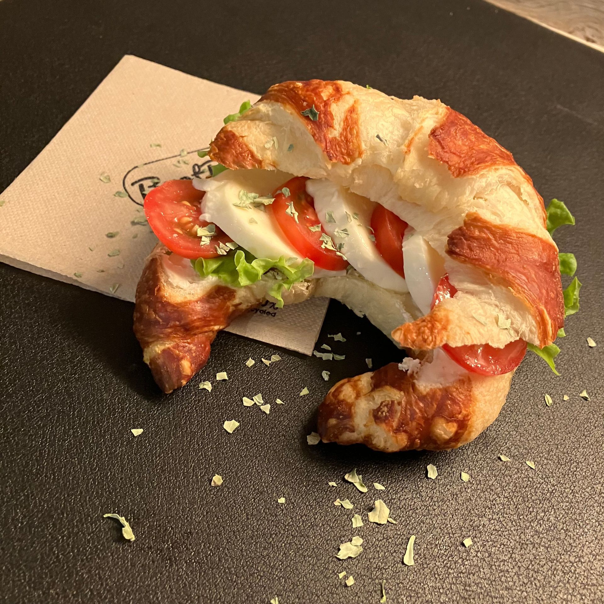 Ein halb gegessenes Sandwich auf einer Serviette auf einem Tisch