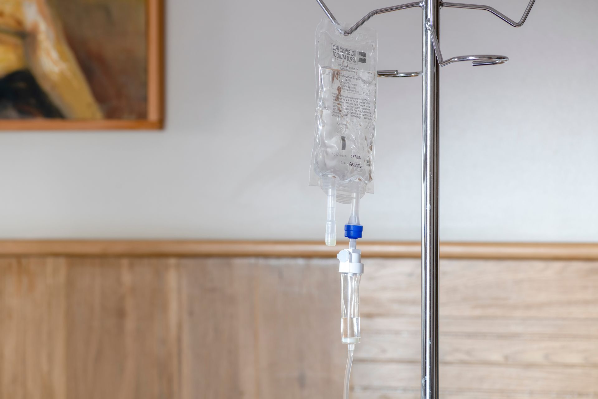 Poche de perfusion suspendue à un pied à perfusion métallique dans une chambre d'hôpital ou de clinique