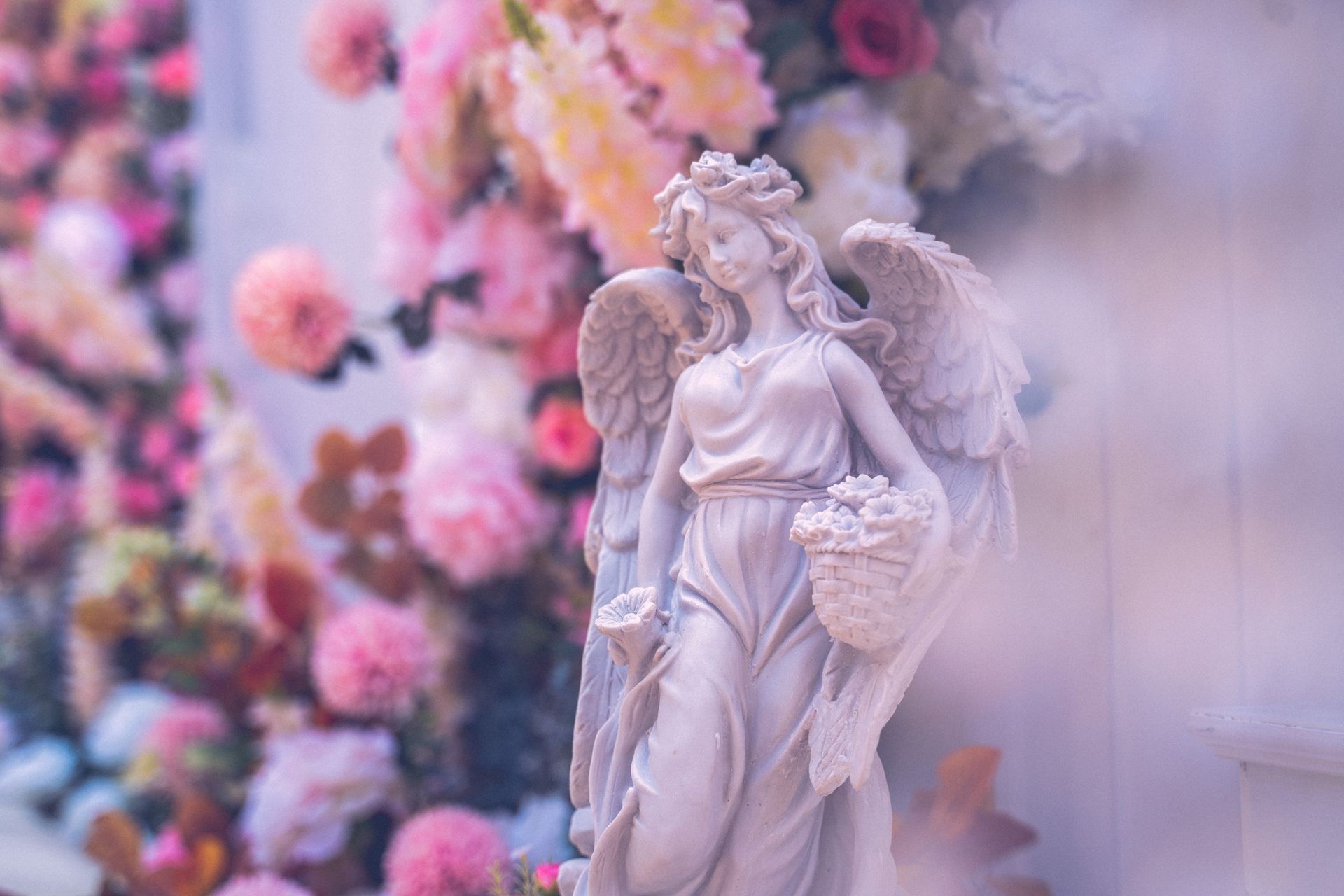 Une statuette avec des fleurs en arrière-plan