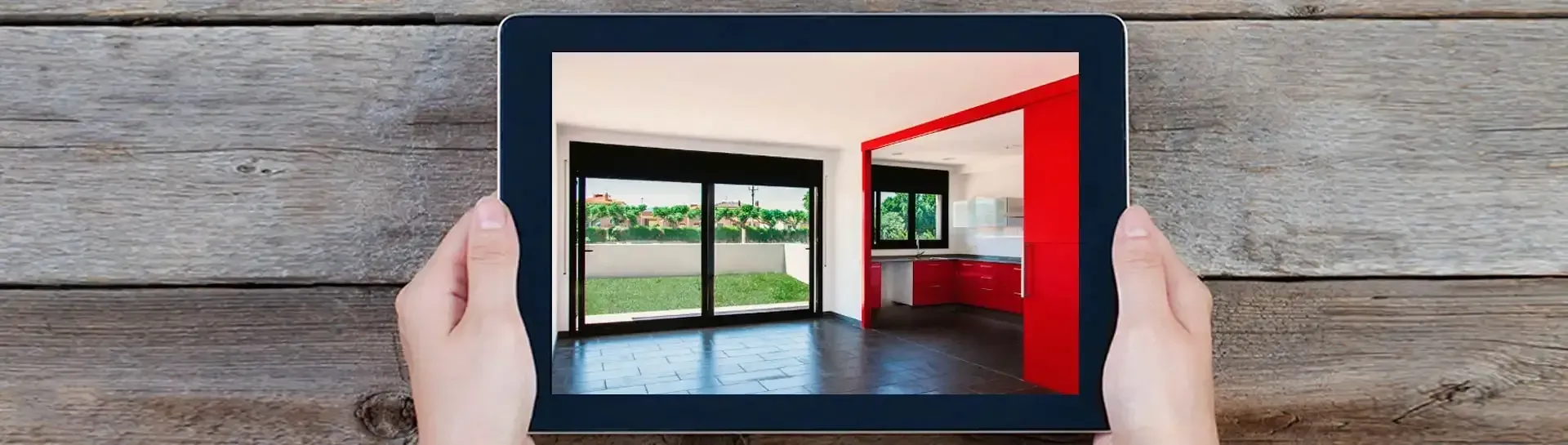 Una persona sostiene una tableta con una imagen de una habitación.