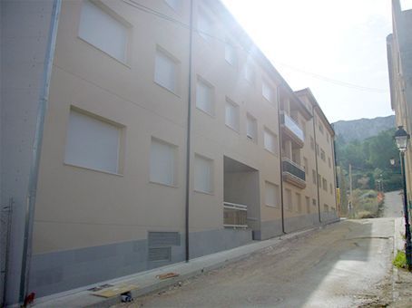 Un edificio con muchas ventanas está al lado de un camino de tierra.