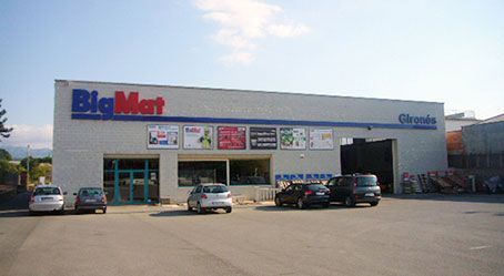 Un gran supermercado con coches aparcados delante.