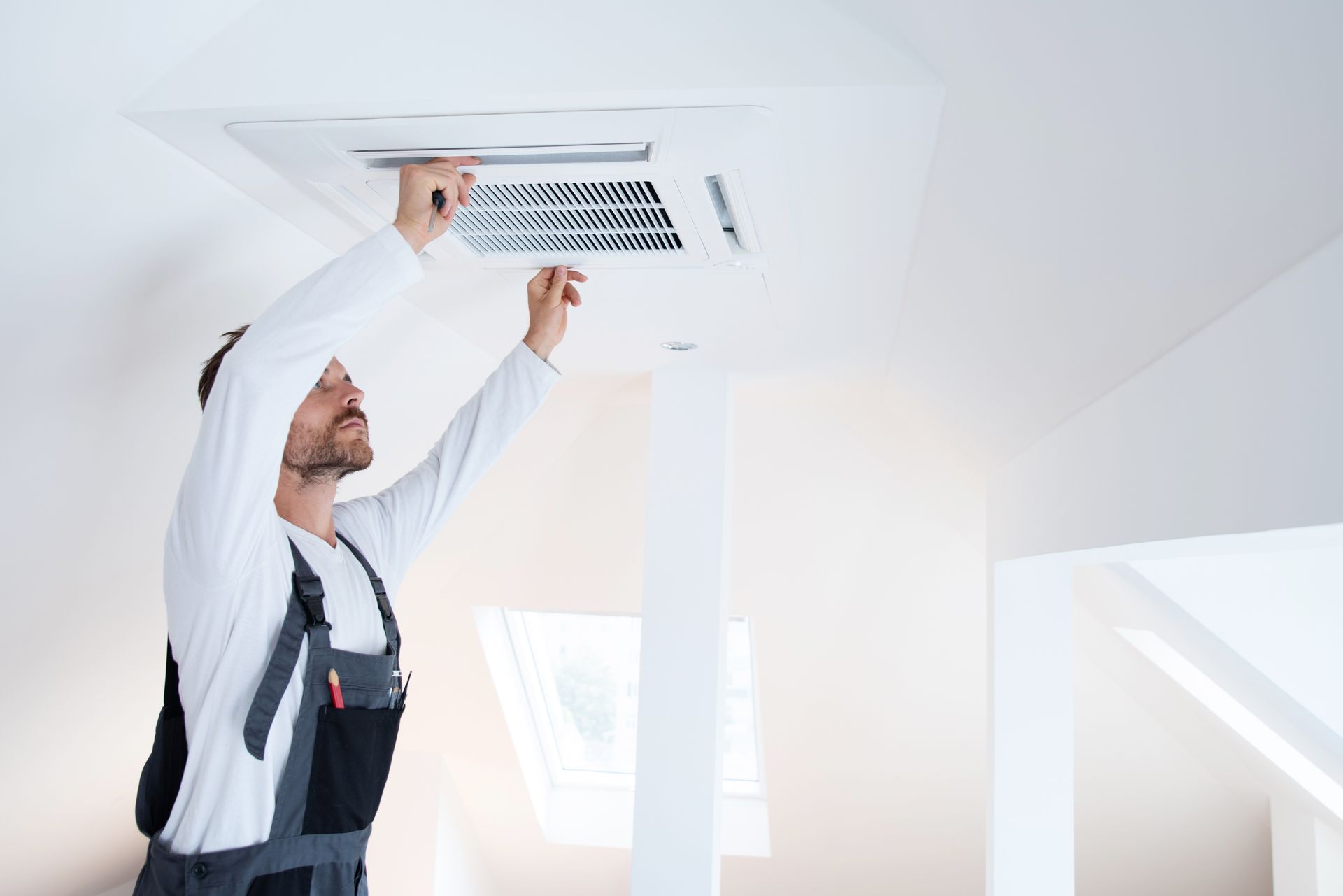 Photo d'un chauffagiste installant un système de climatisation