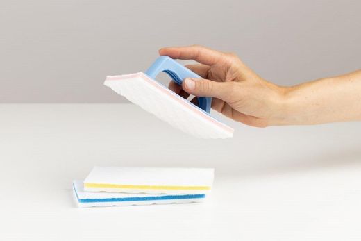 Moderni valkoinen talo mustilla yksityiskohdilla ja puisella terassilla, sininen taivas yläpuolella.