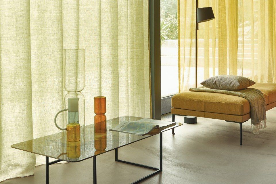 Ein Wohnzimmer mit einem Couchtisch aus Glas und einer gelben Couch.