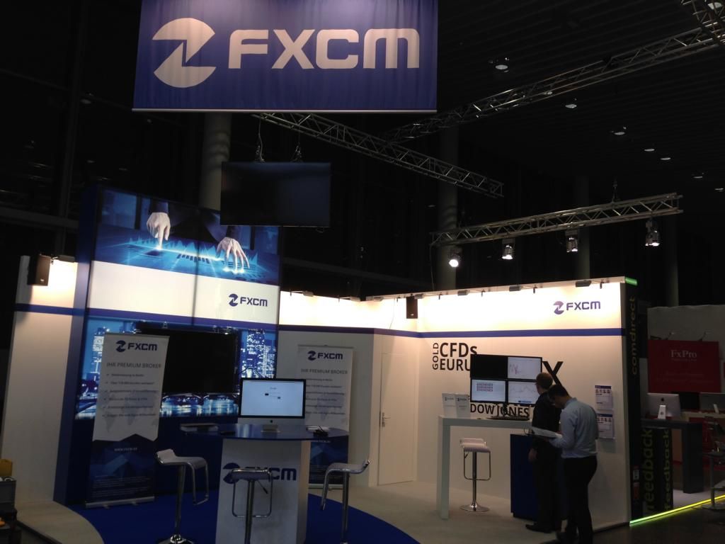Eine blau-weiße Werbung für fxcm hängt an einer Decke