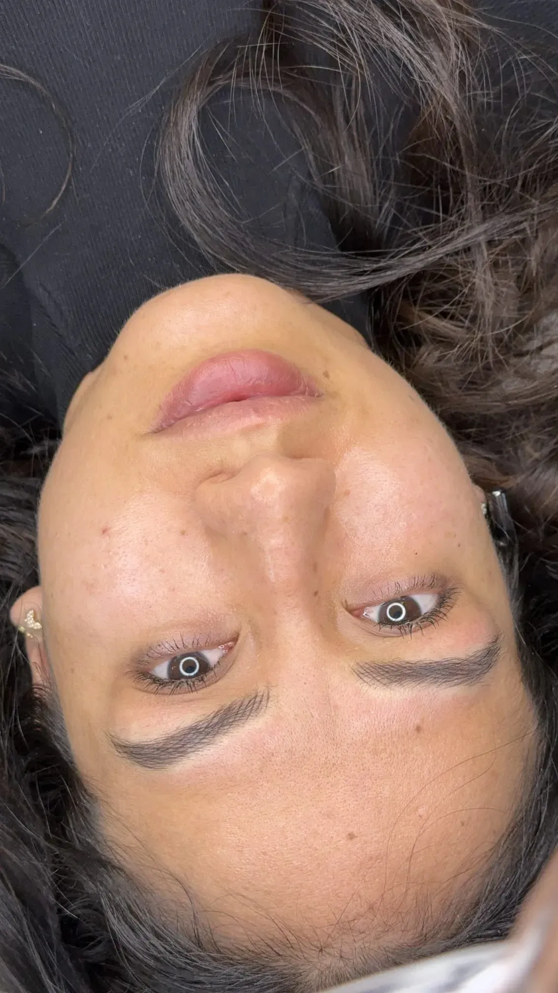 Una mujer está acostada boca arriba con la cabeza hacia abajo.