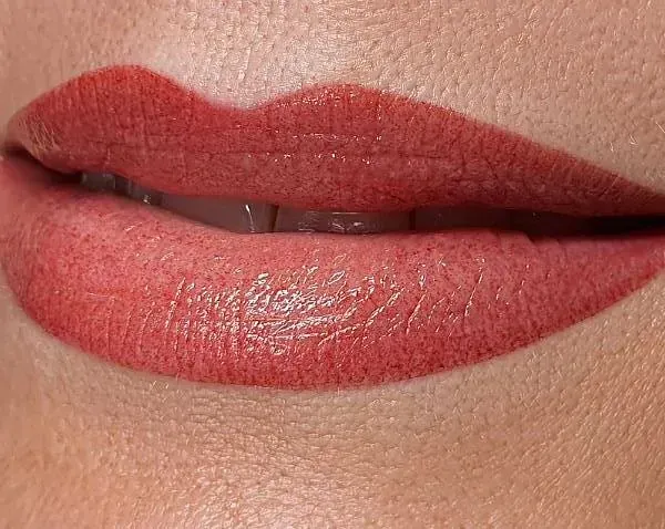 Un primer plano de los labios de una mujer con lápiz labial rojo.