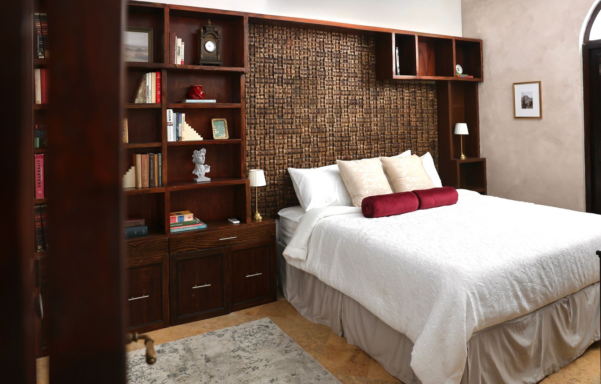 A bedroom with a king size bed and lots of bookshelves