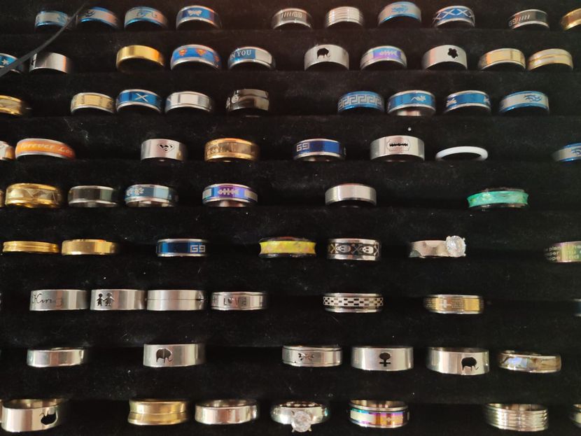 Des rangées de bagues assorties présentées sur un présentoir à bijoux en velours noir.