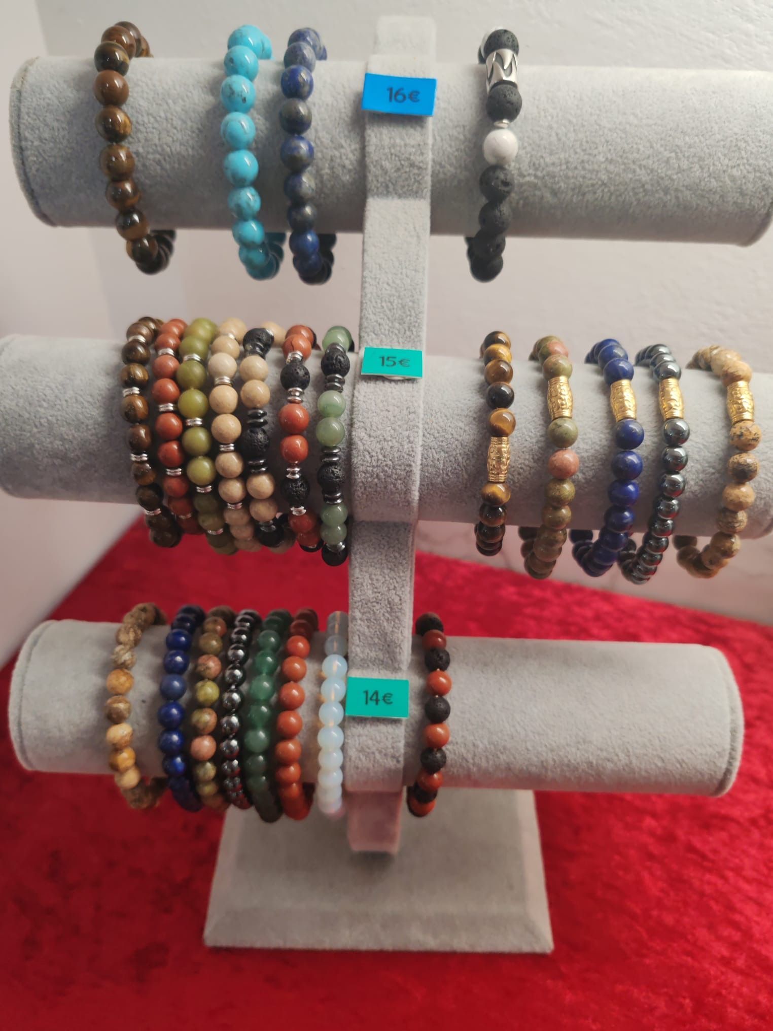 Présentoir à plusieurs bras avec de nombreux bracelets en perles aux couleurs variées.
