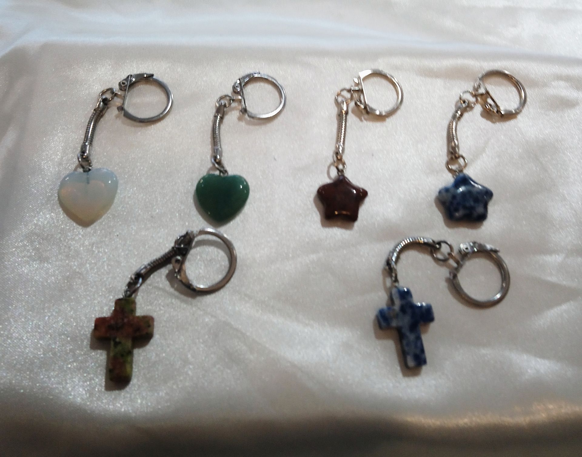 Différents porte-clés en forme de cœur, d'étoile et de croix fabriqués avec des pierres.