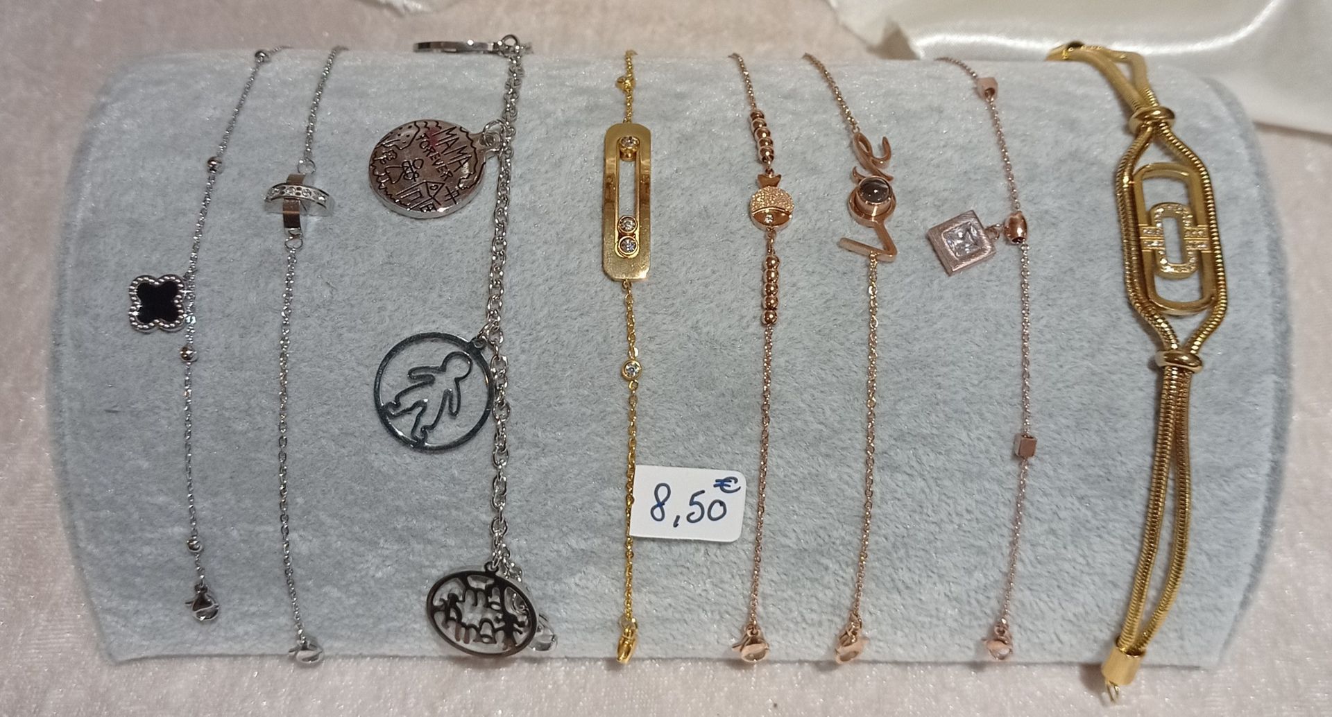 Présentoir à bijoux avec assortiment de bracelets argentés et dorés.