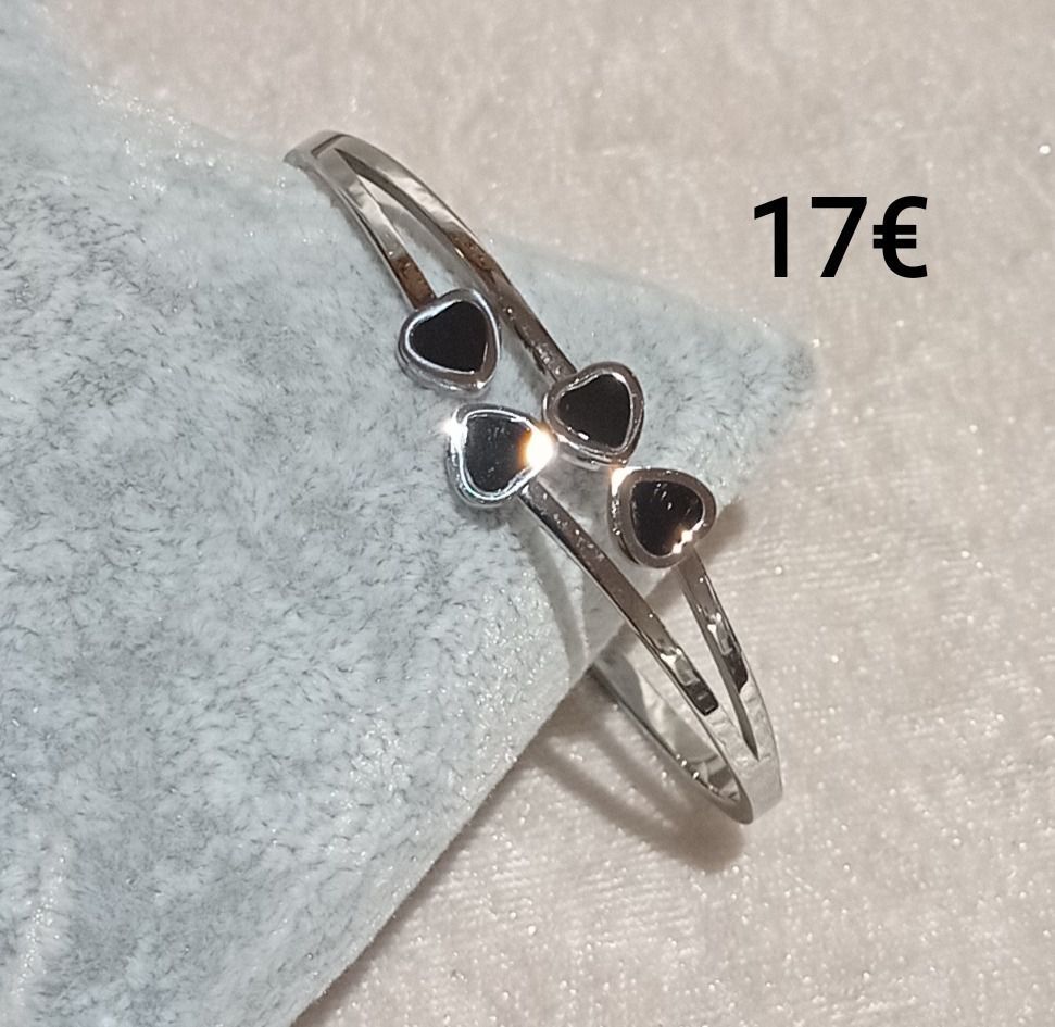 Bague argentée avec des cœurs noirs.