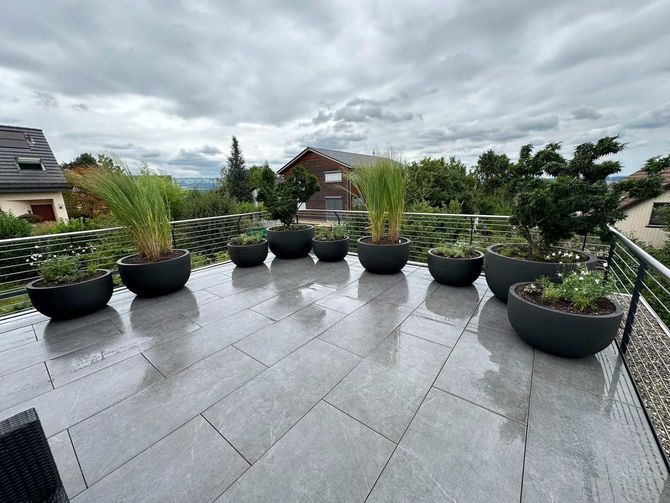 Balkon mit Steinplatten und grossen Pflanzenkübeln