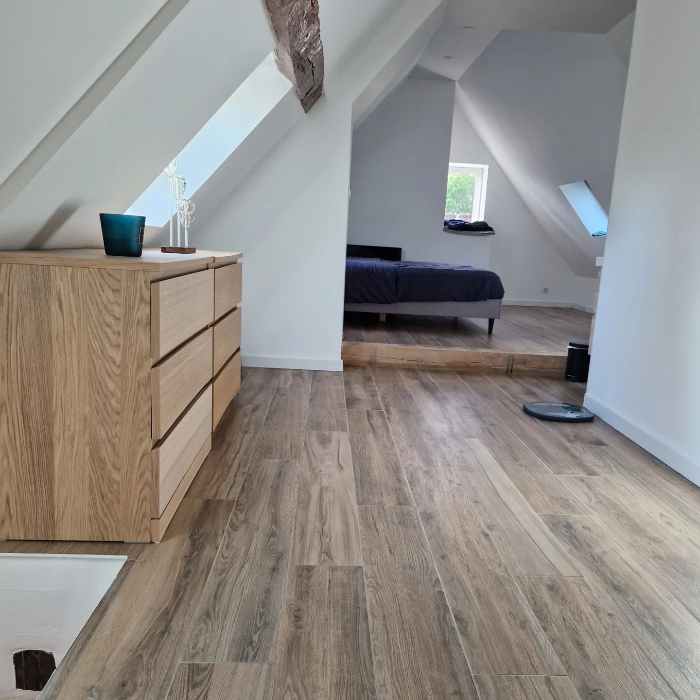 Chambre mansardée avec parquet et cabine de douche en marbre