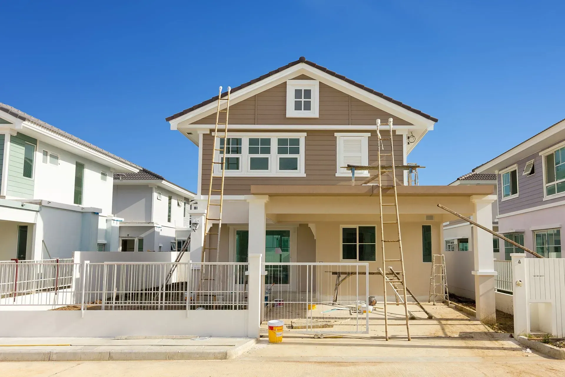 Maison en construction avec extérieur marron et beige; ciel bleu clair.