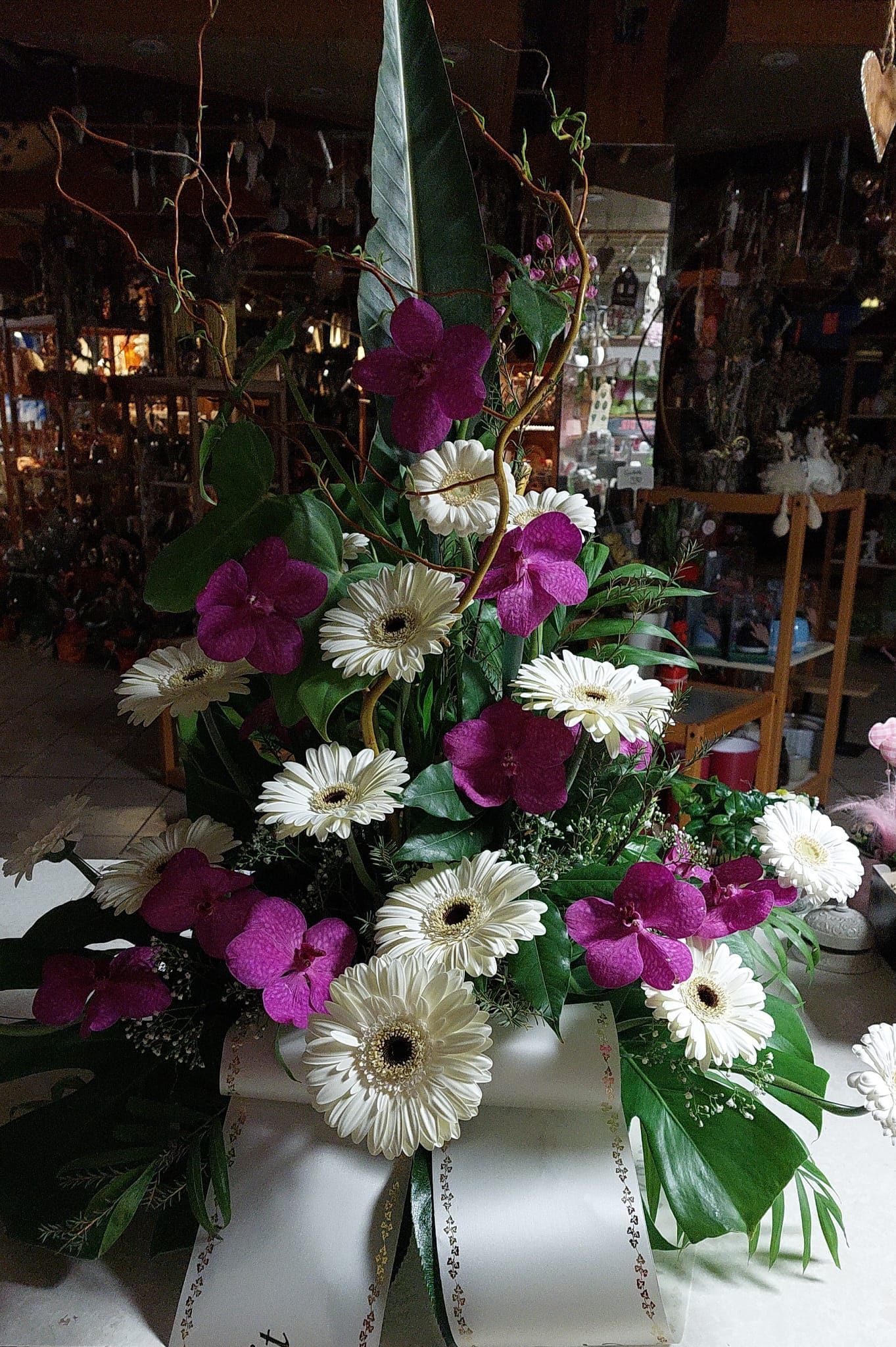 Auf einem Tisch steht ein Strauß violetter und weißer Blumen.