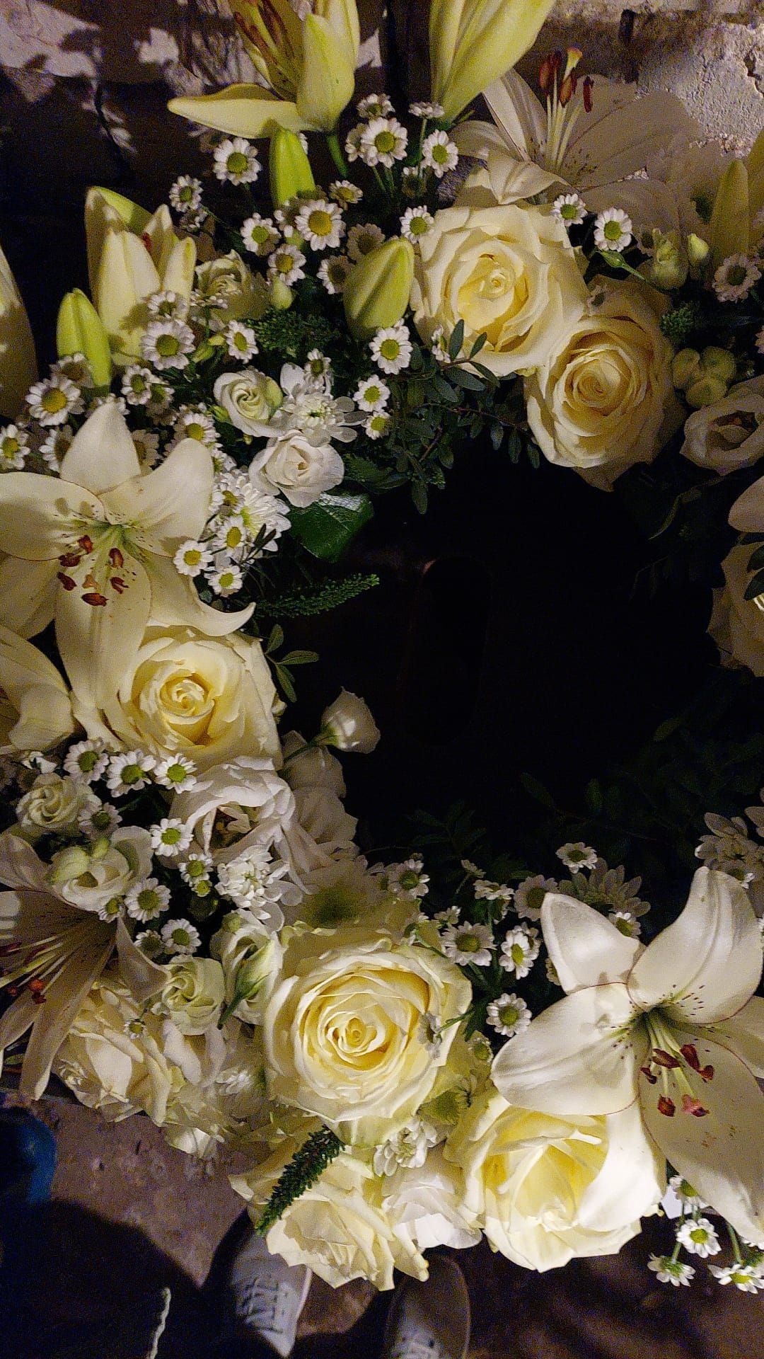 Eine Nahaufnahme eines Kranzes aus weißen Blumen auf einem Tisch.