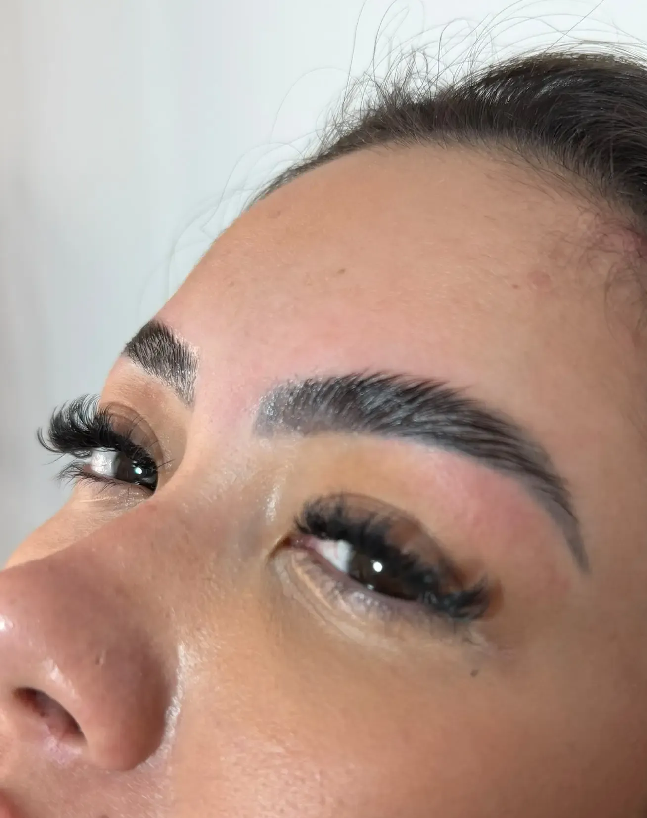 Primer plano de un ojo color avellana con pestañas largas y una ceja bien arreglada.
