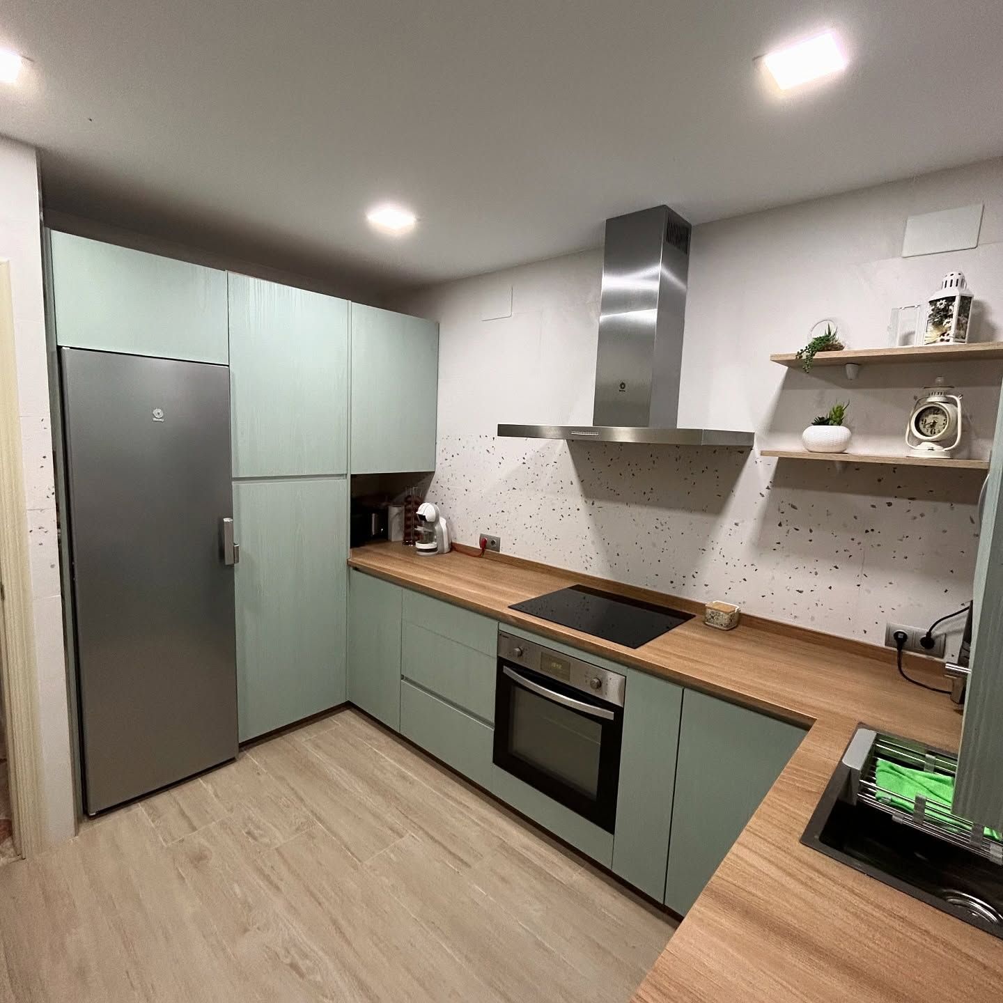Una cocina con electrodomésticos de acero inoxidable y gabinetes de madera.