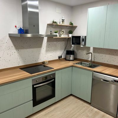 Una cocina con electrodomésticos de acero inoxidable y encimeras de madera.