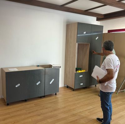 Un hombre está de pie en una habitación sosteniendo un trozo de papel.
