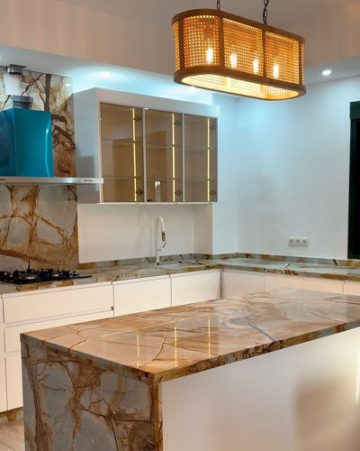 Una cocina con una gran isla y una lámpara de araña colgando del techo.