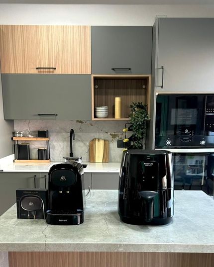 Hay dos cafeteras sobre un mostrador en una cocina.