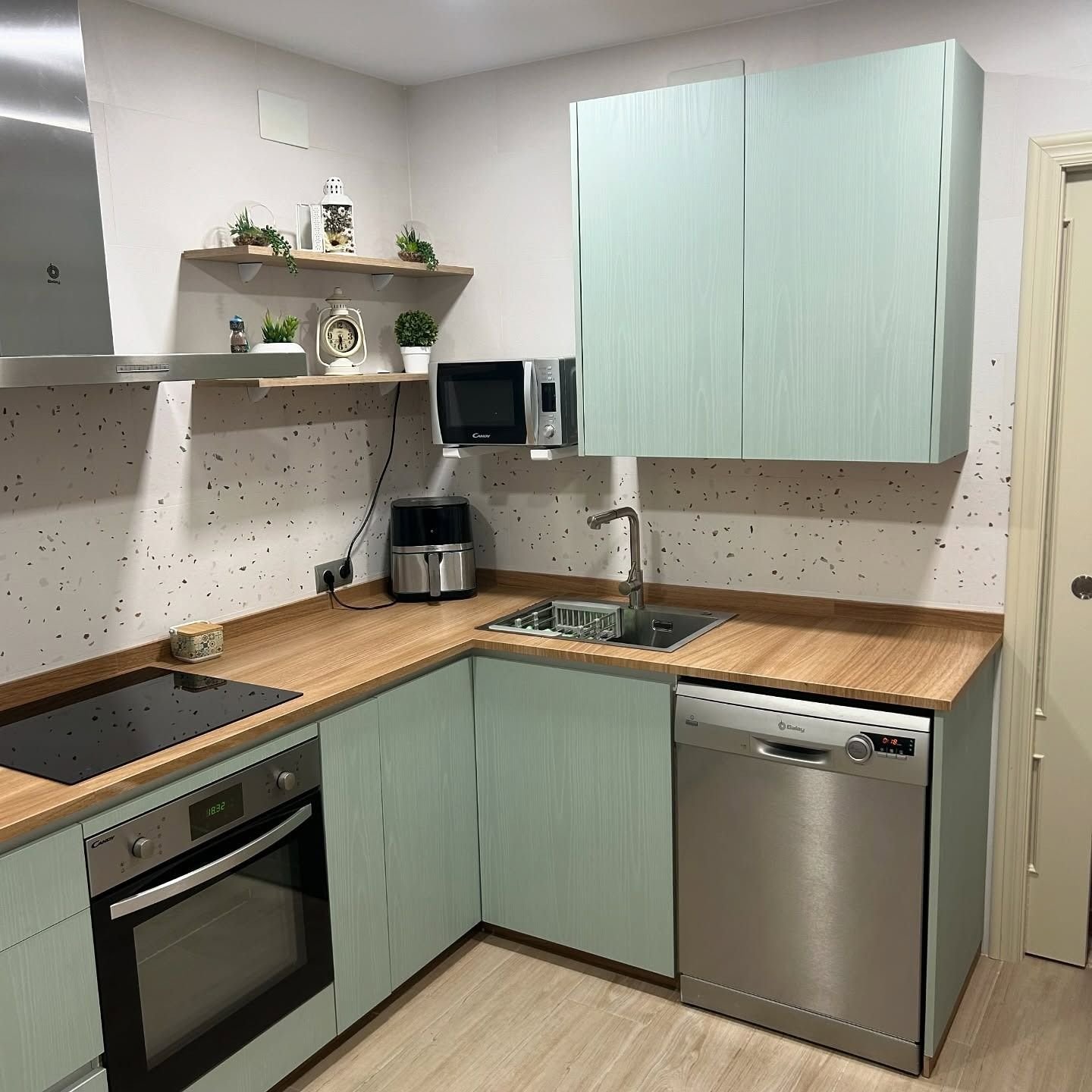 Una cocina con electrodomésticos de acero inoxidable y encimeras de madera.