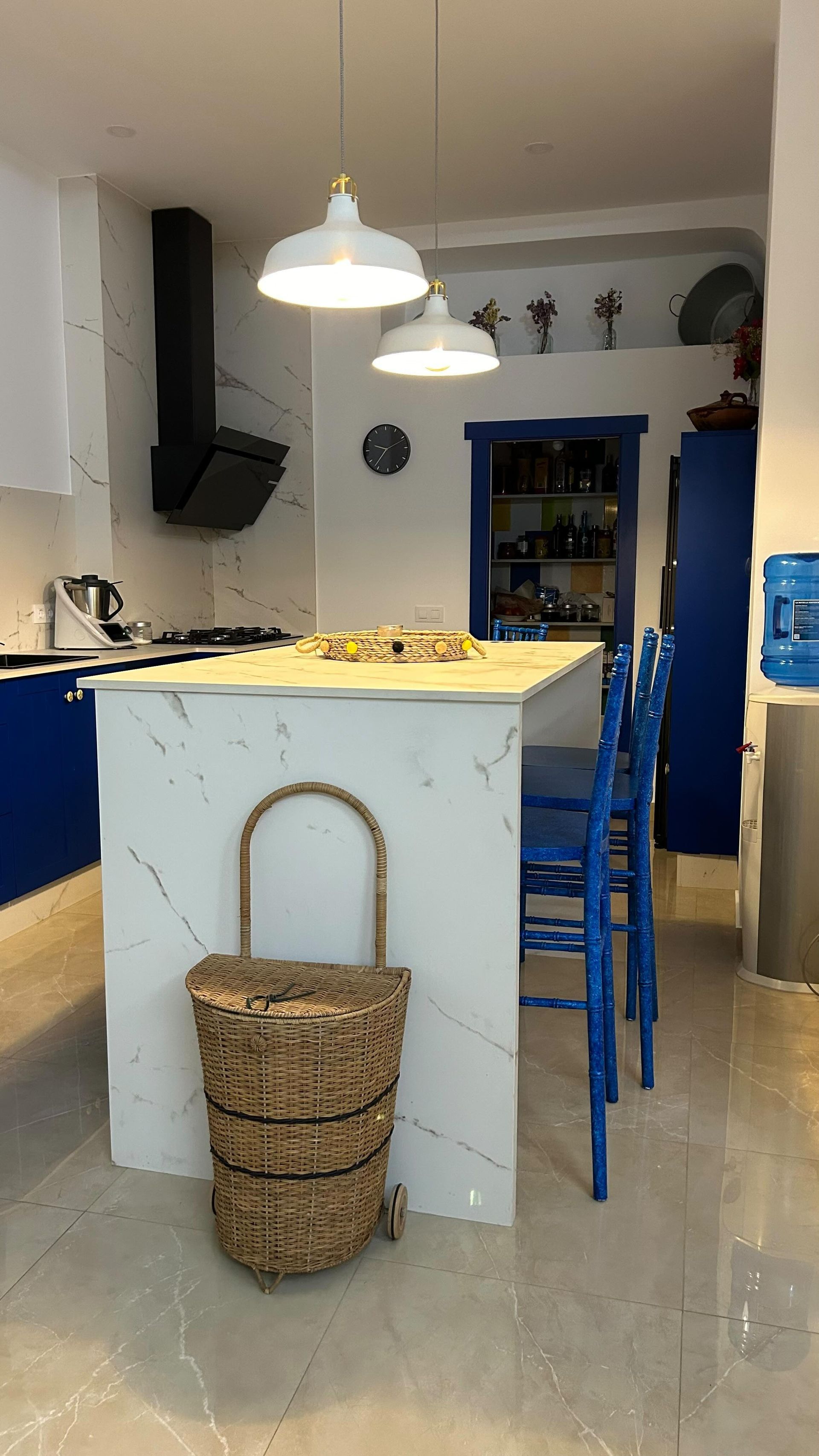 Una cocina con una gran isla y sillas azules.