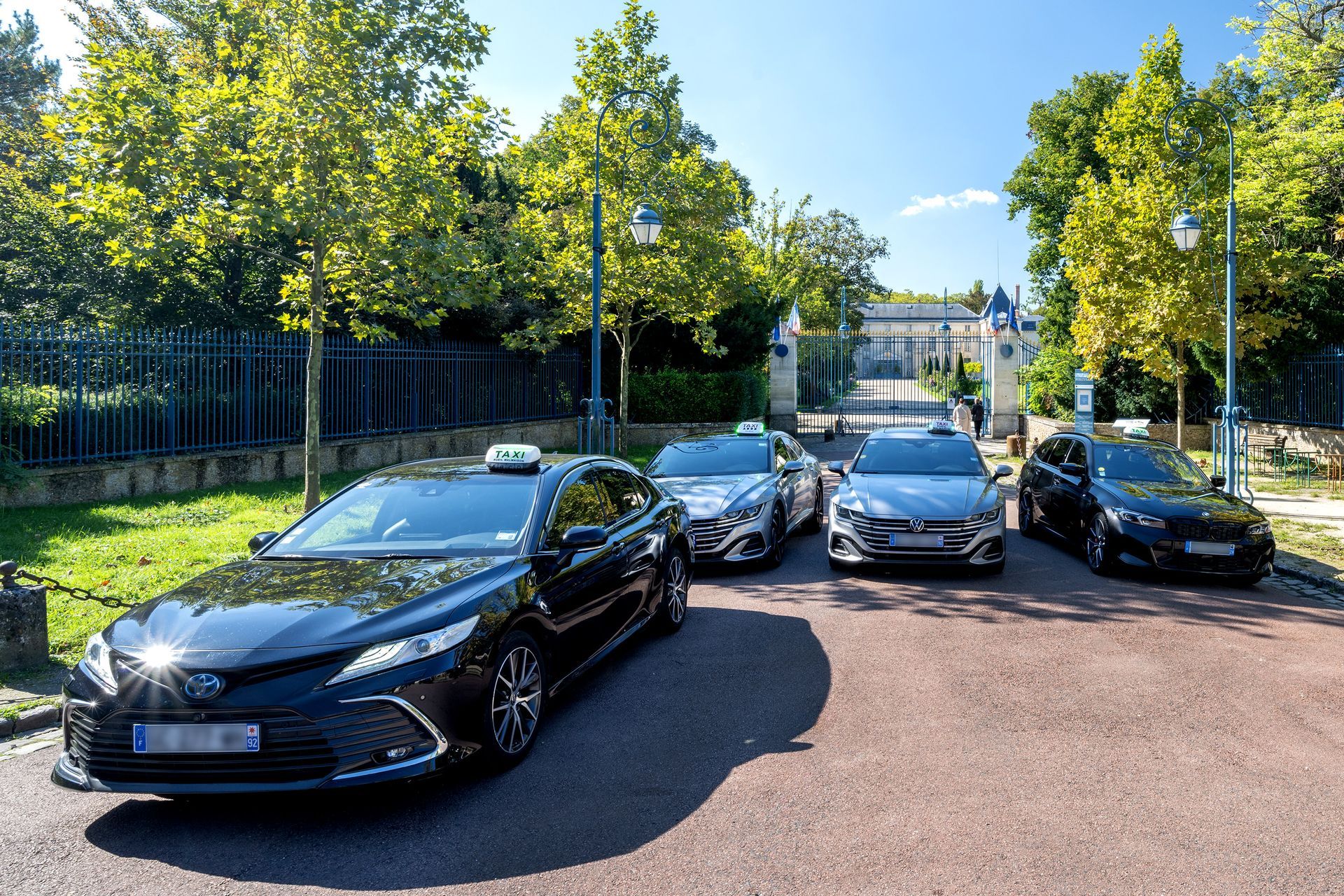 Quatre taxis en stationnement devant un portail