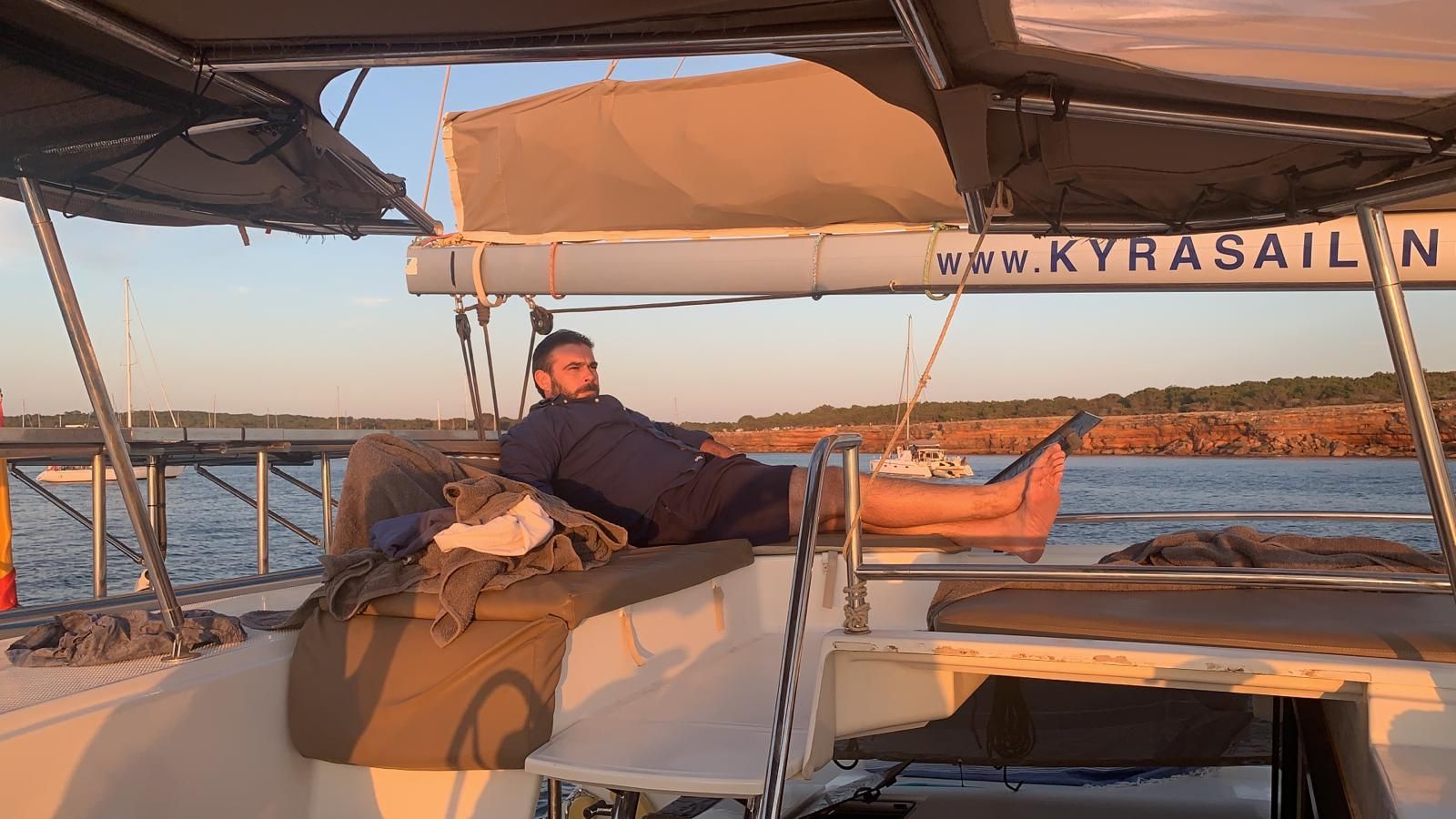 Un hombre está tumbado en la cubierta de un velero. Te ofrecemos un servicio integral de tramitación de siniestros