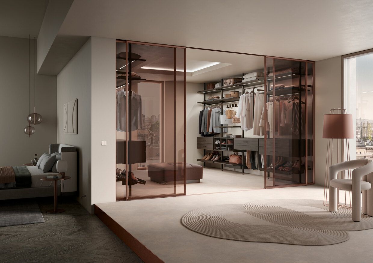 Ein Schlafzimmer mit begehbarem Kleiderschrank und Glasschiebetüren Wohntrend NRW Raumplus