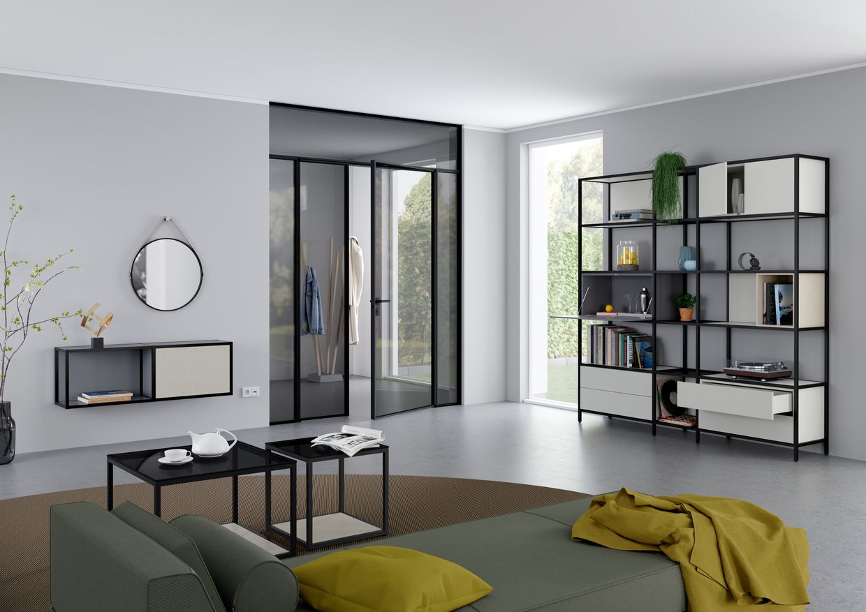 Ein Wohnzimmer mit Couch, Couchtischen, Regalen und Spiegel. Wohntrend NRW Raumplus