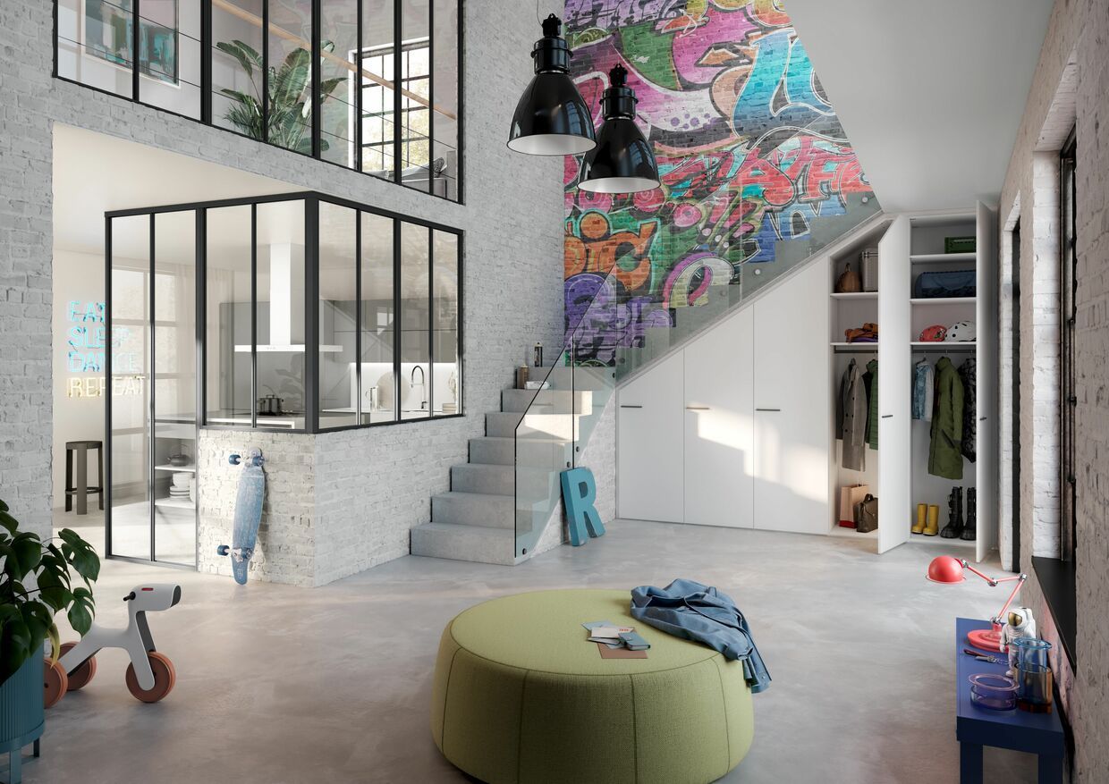 Ein Wohnzimmer mit einer Treppe und einem Gemälde an der Wand. Wohntrend NRW Raumplus