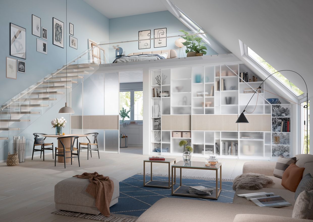 Ein Wohnzimmer mit Couch, Tisch, Stühlen und Treppe. Raumplus Wohntrend NRW