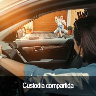 Una mujer conduce un coche y mira por la ventana a un niño.