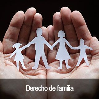Una persona sostiene en sus manos un recorte de papel de una familia.