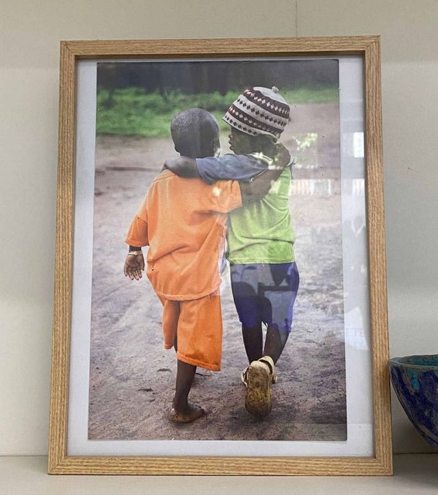 Una fotografía enmarcada de dos niños abrazándose.