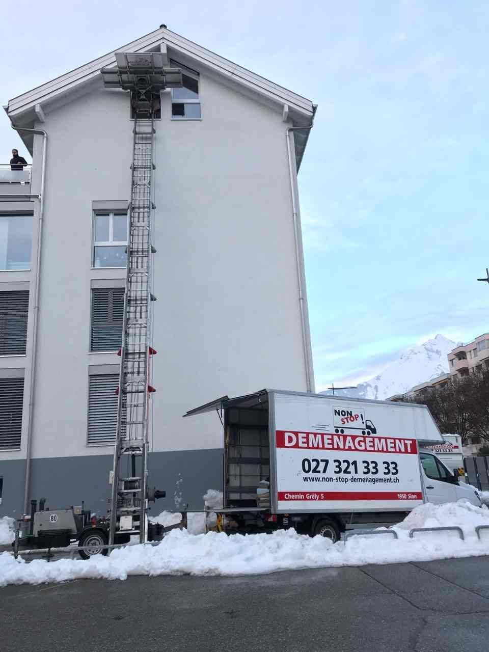 Un camion de déménagement est garé devant un immeuble