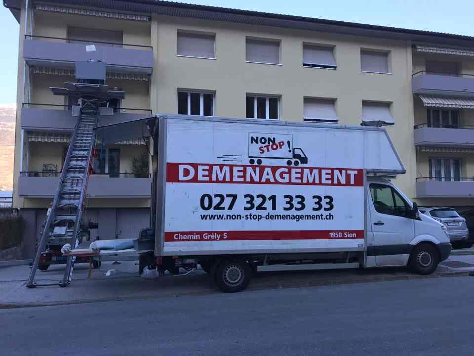 Un camion de déménagement est garé devant un immeuble.